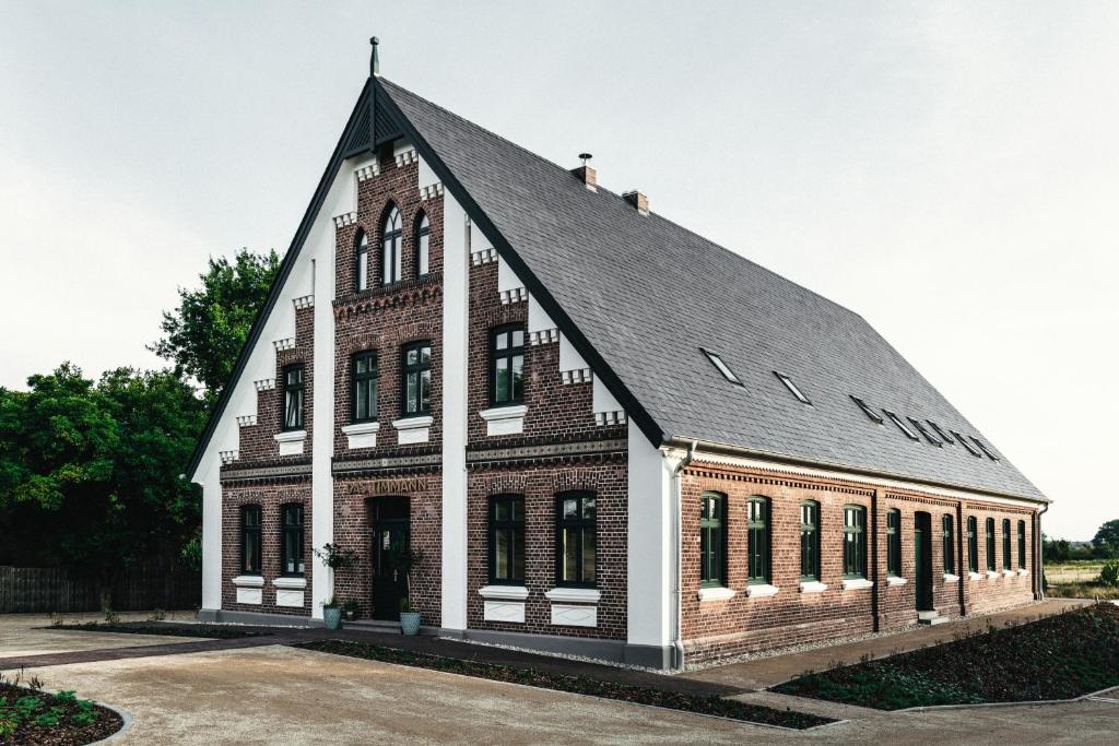 un grand bâtiment en briques avec un toit noir dans l'établissement Das Timmann, à Stelle