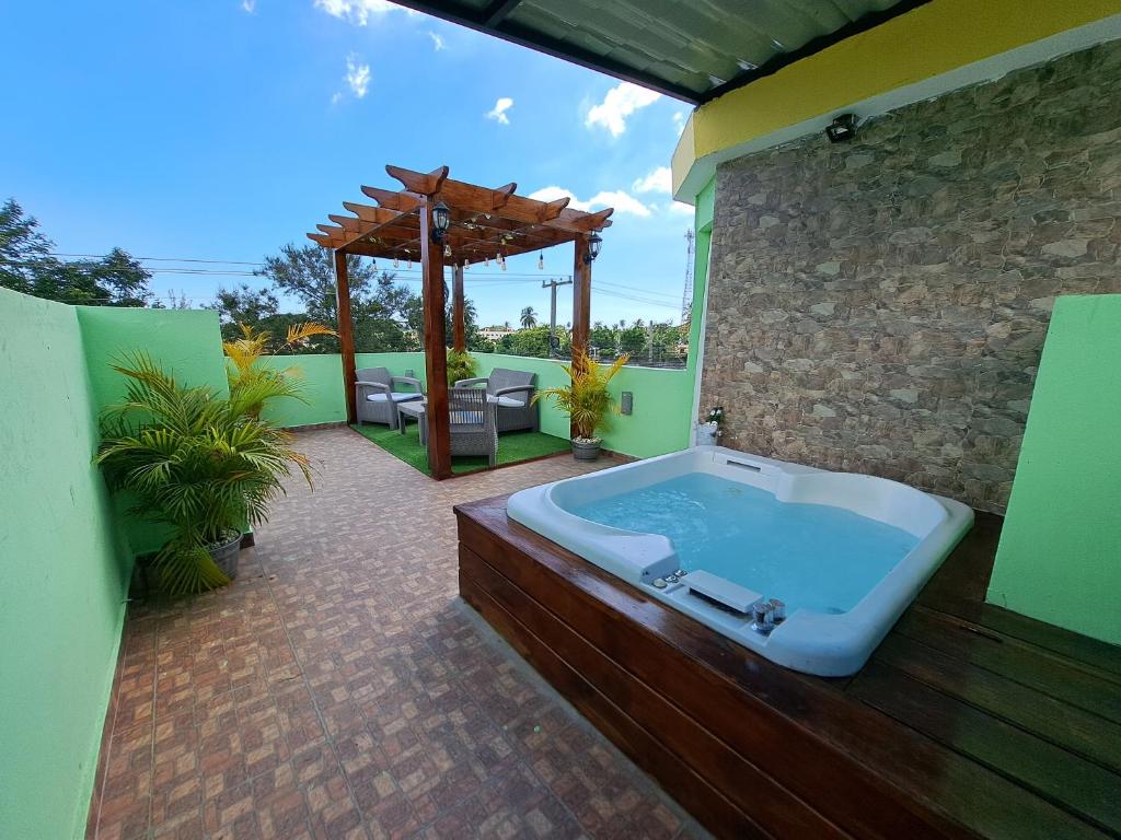 a jacuzzi tub on a patio with a pergola at Hermoso Loft in Santo Domingo