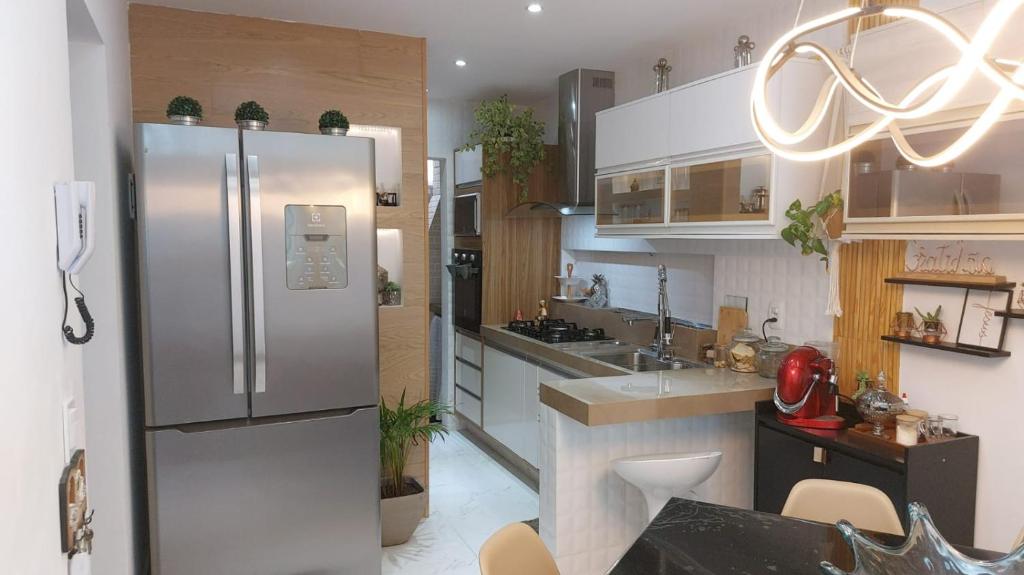 a kitchen with a stainless steel refrigerator at Casa Duplex Praia do Peró - Cinema em Casa in Cabo Frio