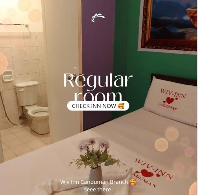 ein Badezimmer mit einem weißen Bett mit einer Vase aus Blumen in der Unterkunft WJV INN Canduman in Mandaue City