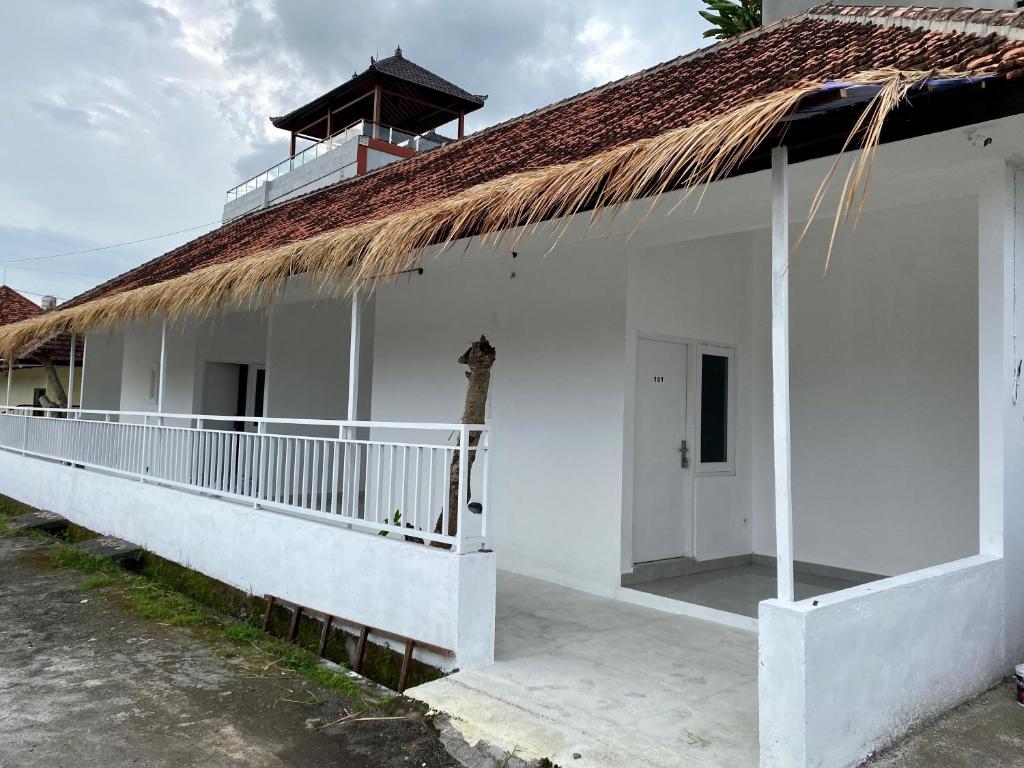 a white building with a thatch roof at My Capsule Canggu in Canggu