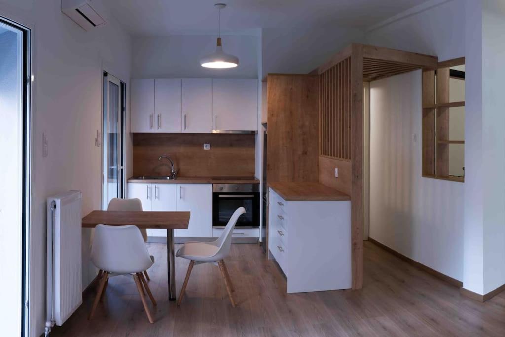 a kitchen with white cabinets and a table and chairs at Volos City Center 1 in Volos