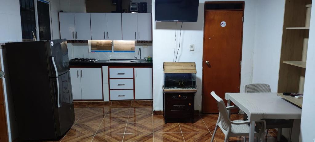 uma cozinha com armários brancos e um frigorífico preto em Posada Dakema em Cartagena de Indias
