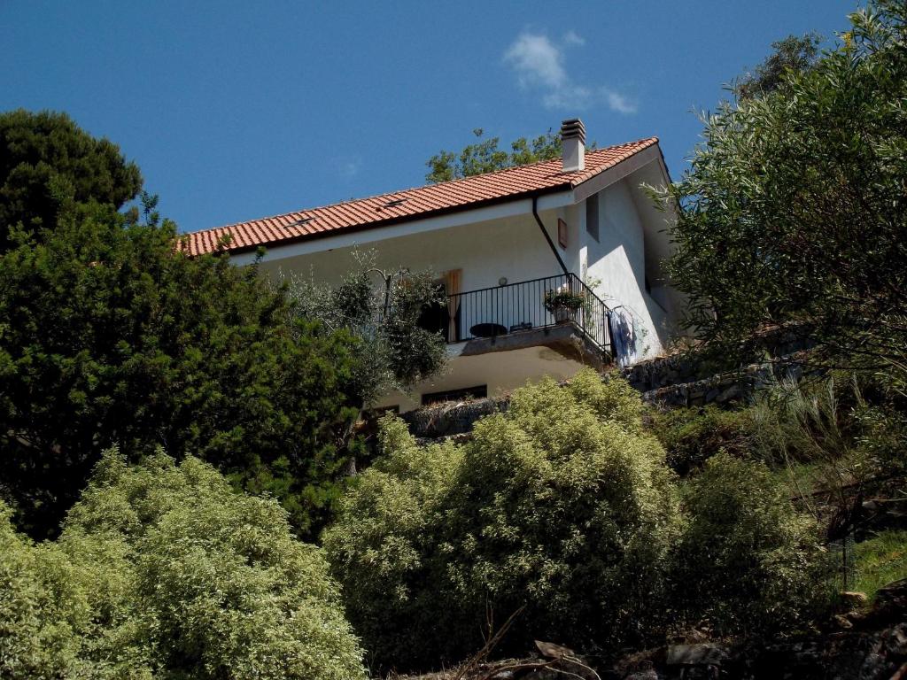 una casa al lado de una colina con árboles en B&B L'Intrigante, en Seborga
