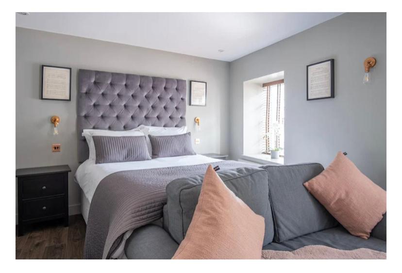 a bedroom with a large bed and a couch at Apartment 2, The Old Bank Apartments in Dronfield