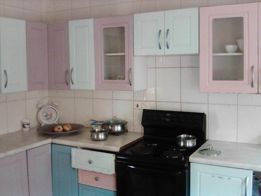 a kitchen with pink and blue cabinets and a stove at Sugar Shack Backpackers Botswana in Gaborone