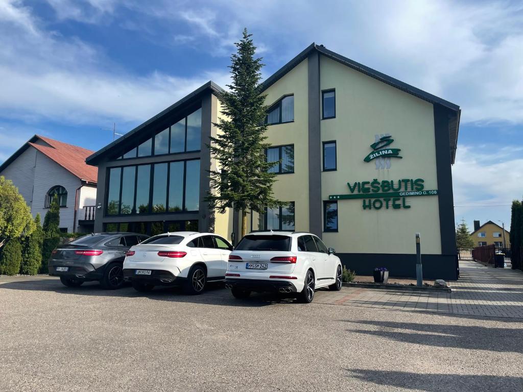 three cars parked in a parking lot in front of a building at Žilina in Marijampolė