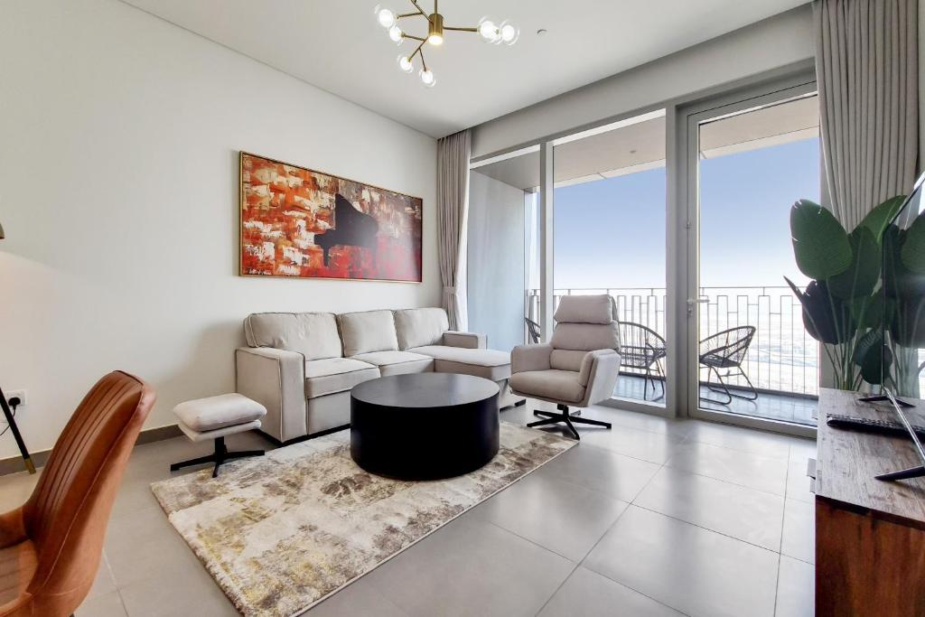 een woonkamer met een bank en een tafel en stoelen bij Primestay - Creek Gate 2 in Dubai Creek Harbour in Dubai