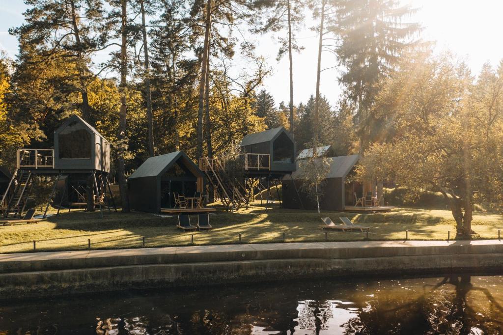 un grupo de chozas junto a un cuerpo de agua en Luxury glamping Chocolate village en Maribor