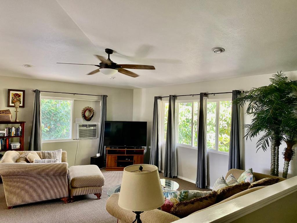 a living room with a couch and a ceiling fan at The big house - 30 days in Kailua-Kona