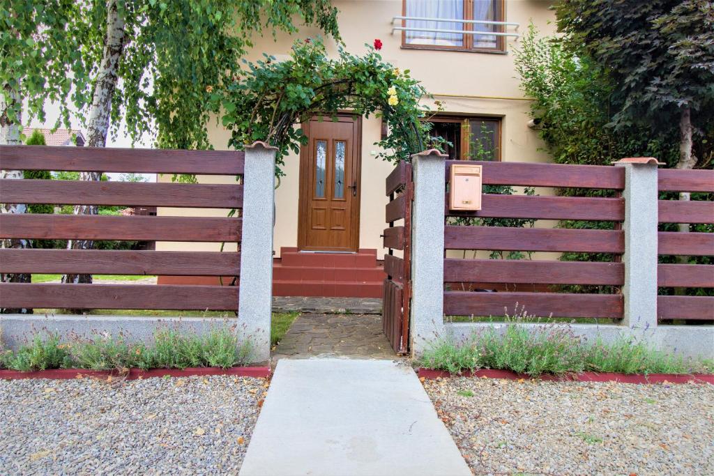 a fence in front of a house with a door at Vila cu Mesteceni in Câmpina