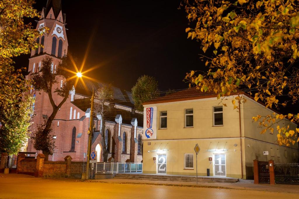 a church with a clock tower at night at Pokoje Samoobsługowe 24/7 in Kałuszyn