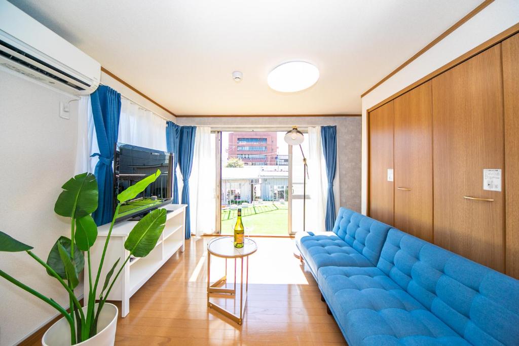 a living room with a blue couch and a table at Yokkaichi Motomachi Hotel in Yokkaichi