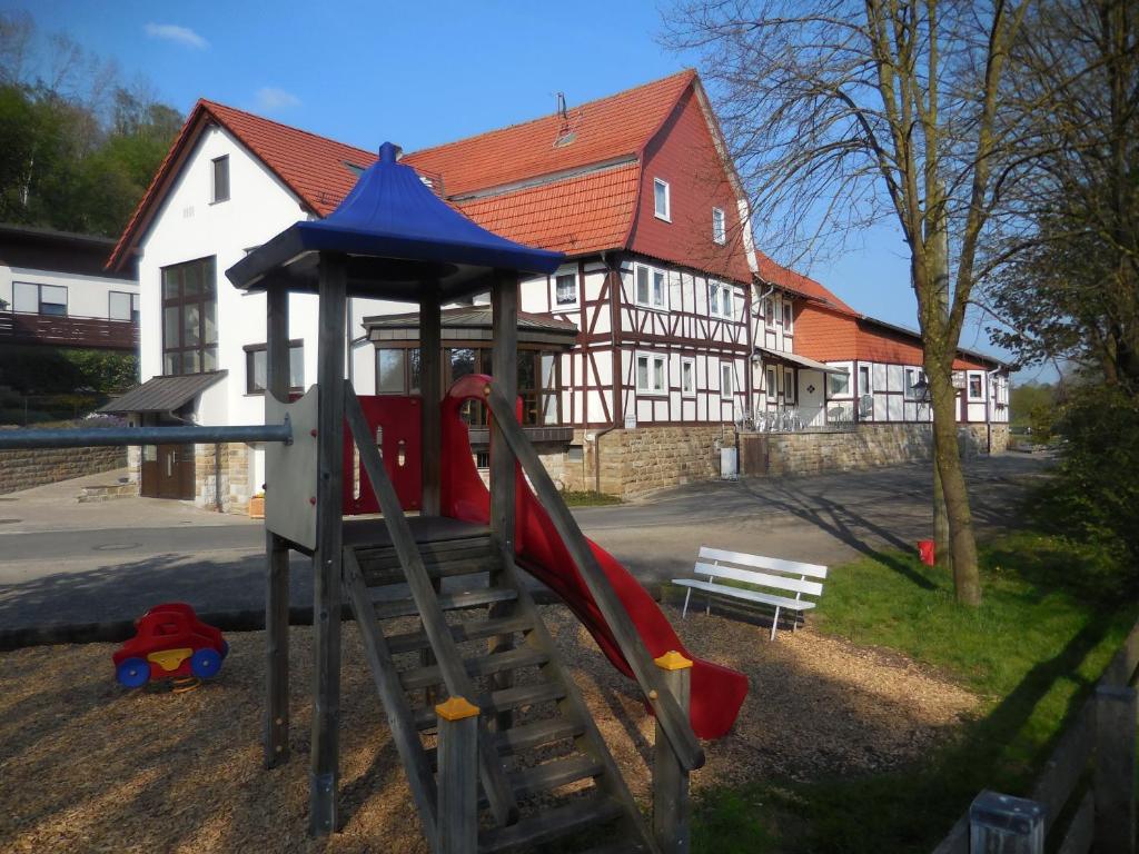 um parque infantil com um escorrega em frente a um edifício em Gasthaus Gonnermann em Sontra