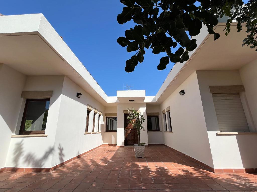 a house with white walls and a brick driveway at Villetta Regina in Teulada