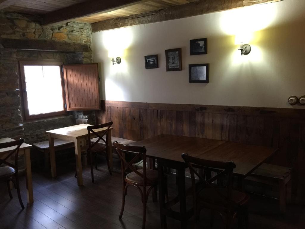 comedor con mesa de madera y sillas en Hostal De Montaña La Aldeya, en Villablino