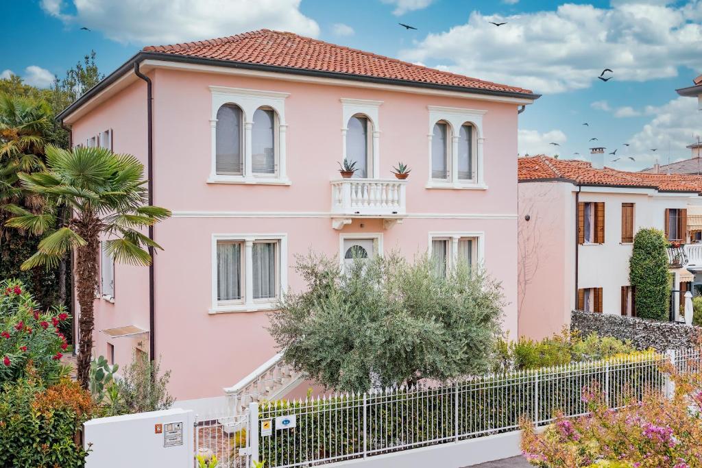 una casa rosa con una valla delante en B&B Villa Rosa, en Padua
