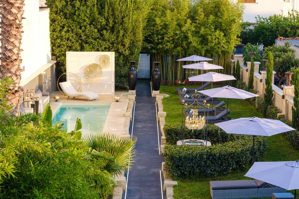 a pool with chairs and umbrellas next to a building at Maison Boutique At in San Pietro in Lama