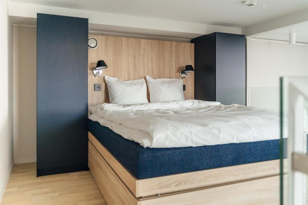a bedroom with a large bed with a blue headboard at UNITY Helsinki in Helsinki