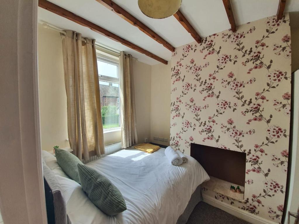 a small bedroom with a bed and a window at Newcastle Park House in Stoke on Trent
