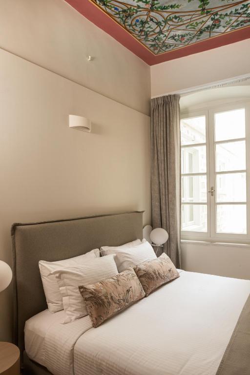 a bedroom with a bed with a painted ceiling at SYROS SOUL LUXURY SUITES in Ermoupoli