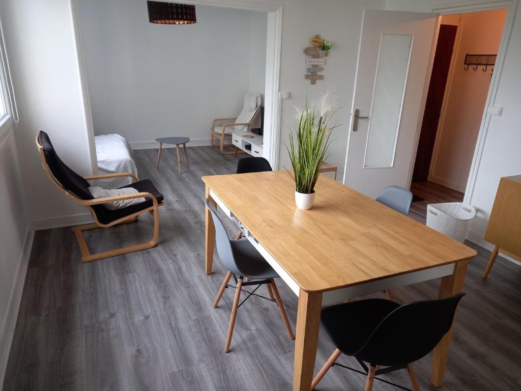 ein Wohnzimmer mit einem Tisch und Stühlen in der Unterkunft L'escale champenoise , wifi garage parking privè gratuit in Châlons-en-Champagne