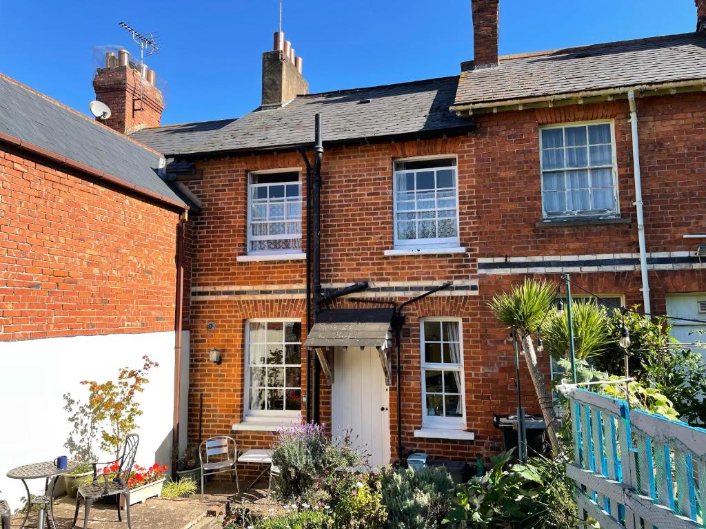 a red brick house with a white door at Seagulls Cottage in the heart of Exmouth in Exmouth