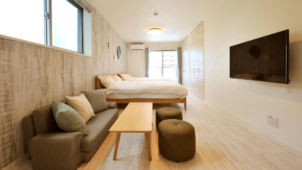 ein Wohnzimmer mit einem Sofa und einem Bett in der Unterkunft RakutenSTAY x Shamaison Osaka Dekijima - 304 in Osaka