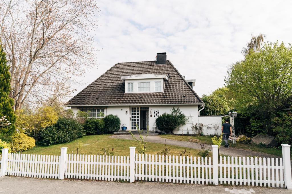 a white picket fence in front of a white house at Fördeblick in Flensburg