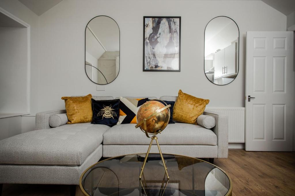 uma sala de estar com um sofá e dois espelhos em Crieff House em Crieff