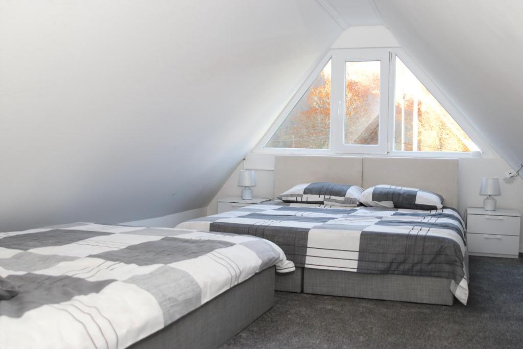 2 camas en un dormitorio con ventana en My sweet home Vrhpraca Jahorina, en Jahorina