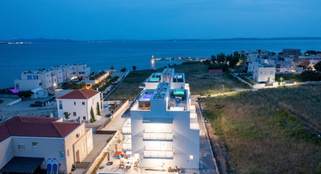 a group of white buildings with the ocean in the background at Villa Miri III in Privlaka