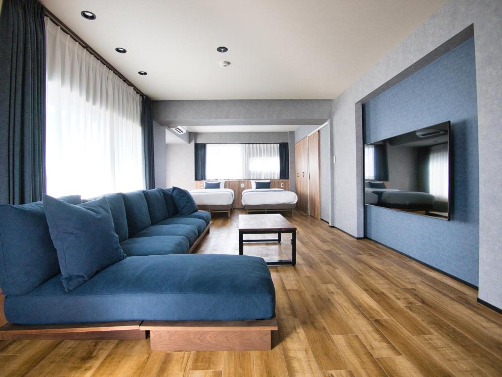 a living room with a blue couch and a tv at ulu Tokyo in Tokyo