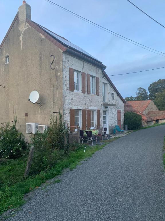 una vieja casa de piedra al lado de una carretera en Busset Liages situé dans le Bourbonnais jusqu’à 6 personnes, en Busset