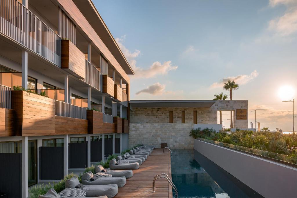 - une vue sur l'extérieur d'un bâtiment avec piscine dans l'établissement Ikones Seafront Luxury Suites, à Réthymnon