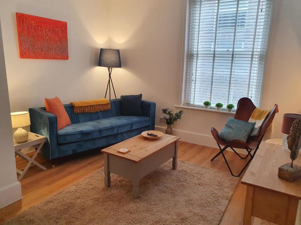 sala de estar con sofá azul y mesa en One Bedroom Flat Central Ipswich en Ipswich