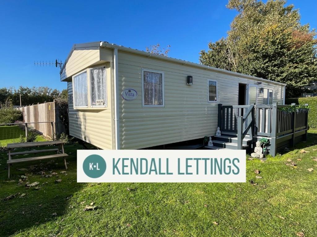 una casita diminuta con un cartel que lee los ajustes de perrera en Stoke Clump (Green Lawns), en Selsey