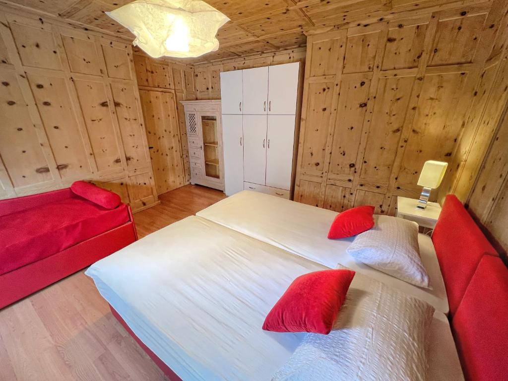 a bedroom with a large white bed and red pillows at Appartamenti Mottini Plaza in Livigno