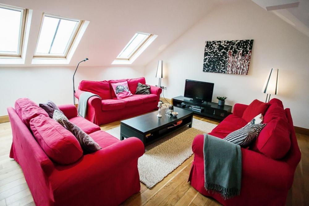 sala de estar con 2 sofás rojos y TV en Big Moo, en Llanrhyddlad