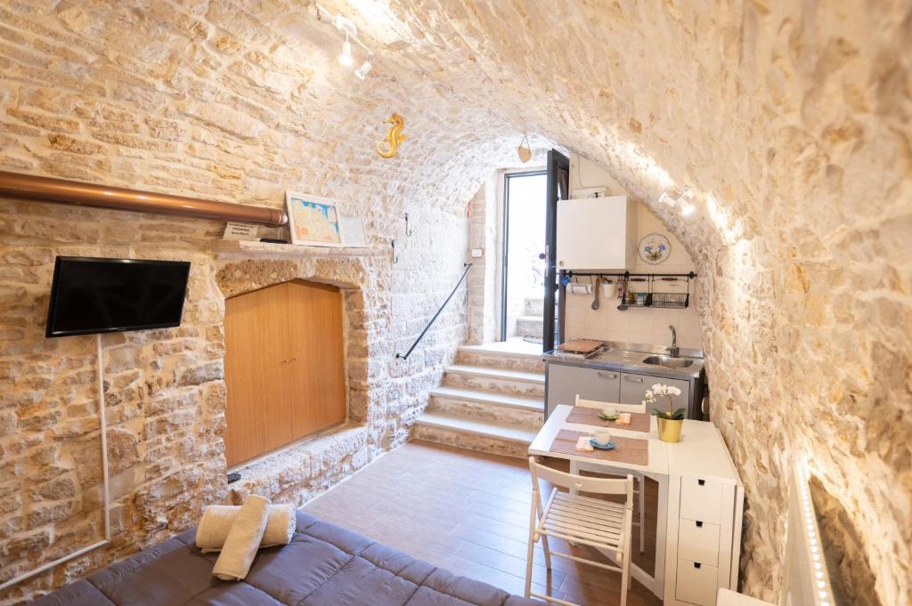 ジョヴィナッツォにあるPiccola Pietra Biancaの石壁のリビングルームとキッチンが備わります。