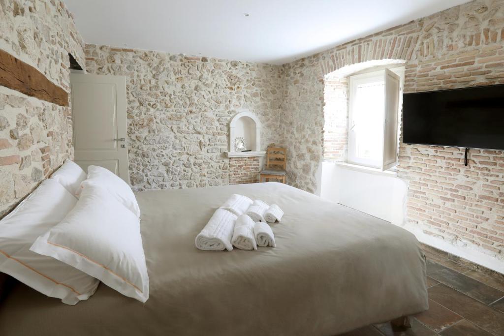 um quarto com uma cama com toalhas em Le dimore nel borgo em Pescocostanzo