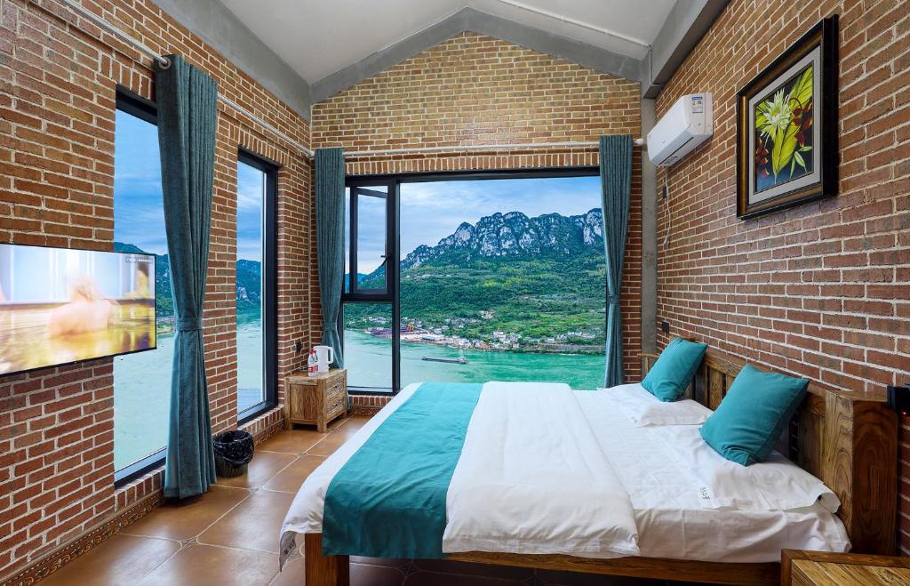 een slaapkamer met een bed en een groot raam bij Yosemite Riverview Homestay in Yichang