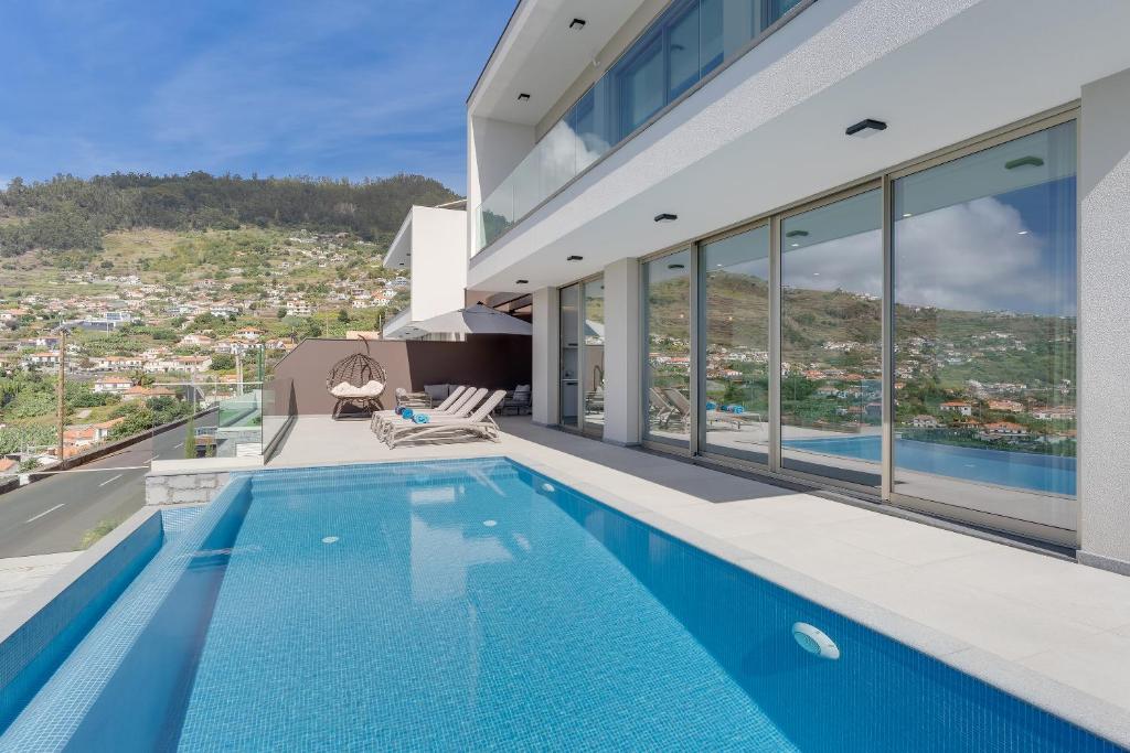 a house with a swimming pool with a view at Luxury Villa Bianca by Holiday Rental Madeira in Arco da Calheta