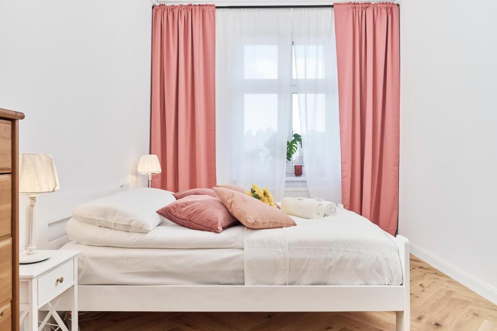 a bedroom with a bed with pink curtains and a window at Family Apartment - 74m2 - Wapienna by Renters in Wrocław