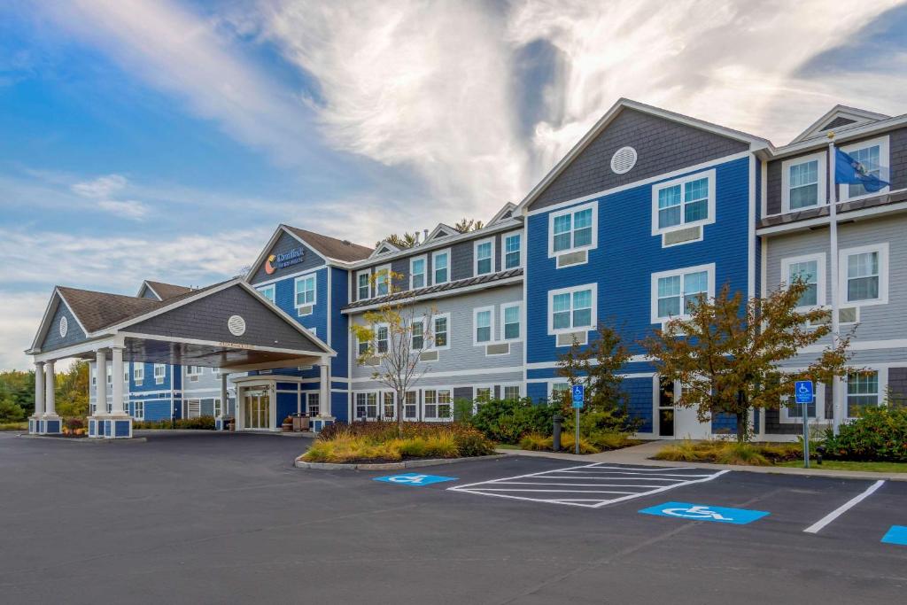 um grande edifício azul com estacionamento em Comfort Inn & Suites Wilton em Wilton