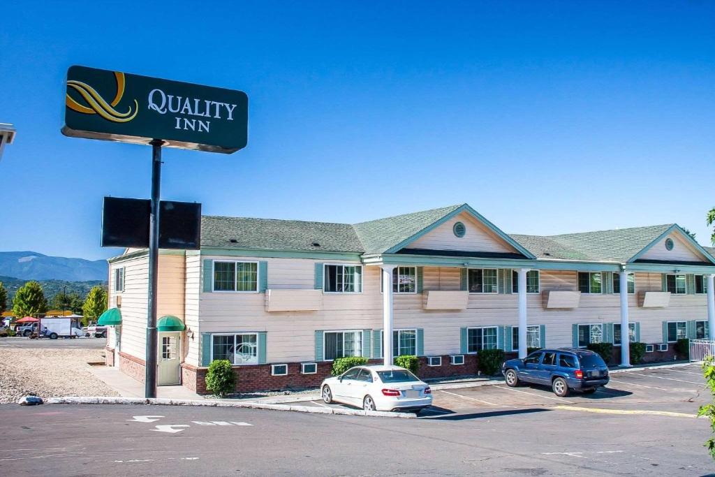 a hotel with cars parked in front of a building at Quality Inn in Grants Pass