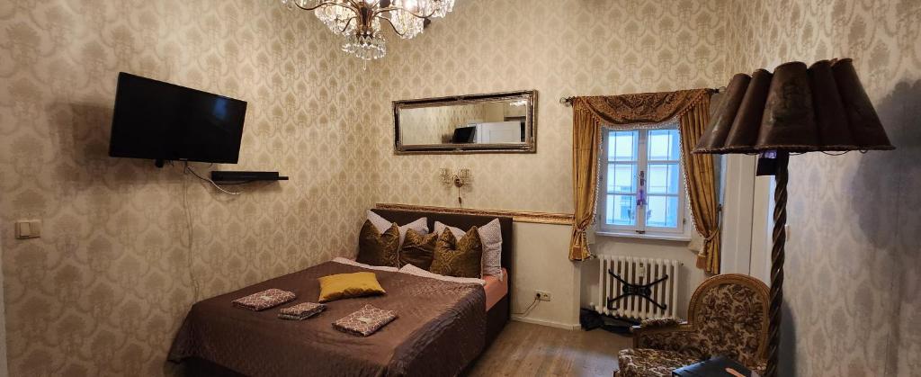 sypialnia z łóżkiem i telewizorem z płaskim ekranem w obiekcie St. Terezie - Baroque Residence w Pradze