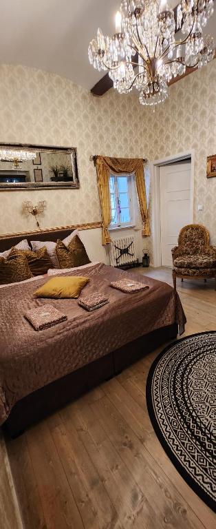 sypialnia z dużym łóżkiem i żyrandolem w obiekcie St. Terezie - Baroque Residence w Pradze