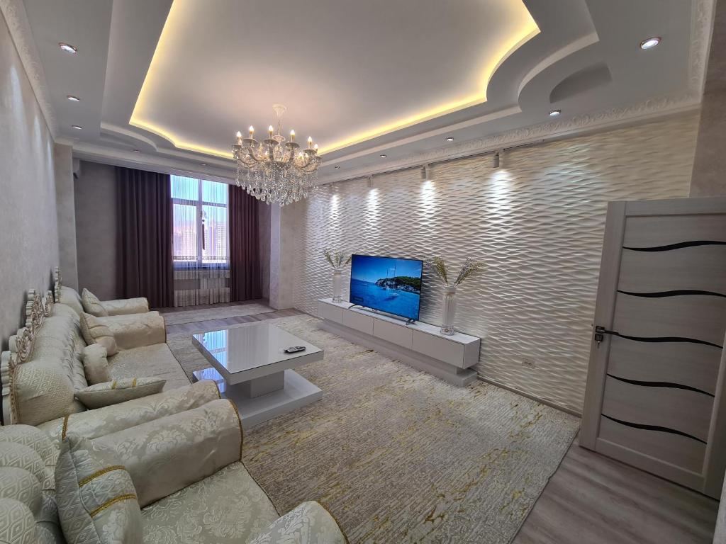 a living room with a couch and a tv at Excellent 2-room apartment bright and cozy in Dushanbe