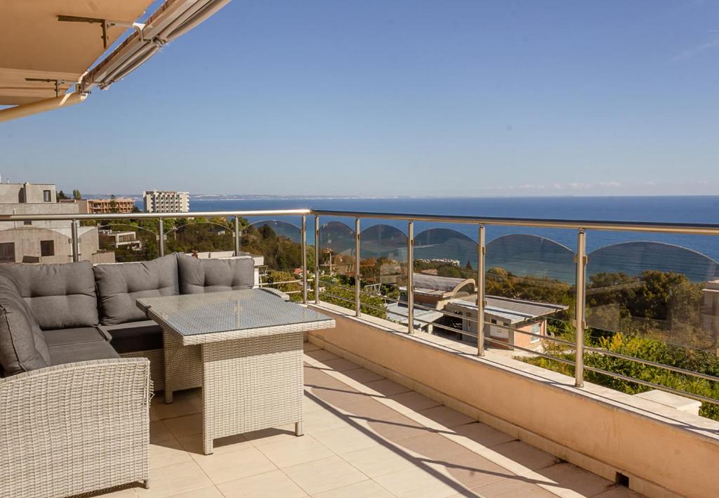 a balcony with a couch and a table and the ocean at Spacious 3BD Flat with Large Terrace & Sea View in Varna City